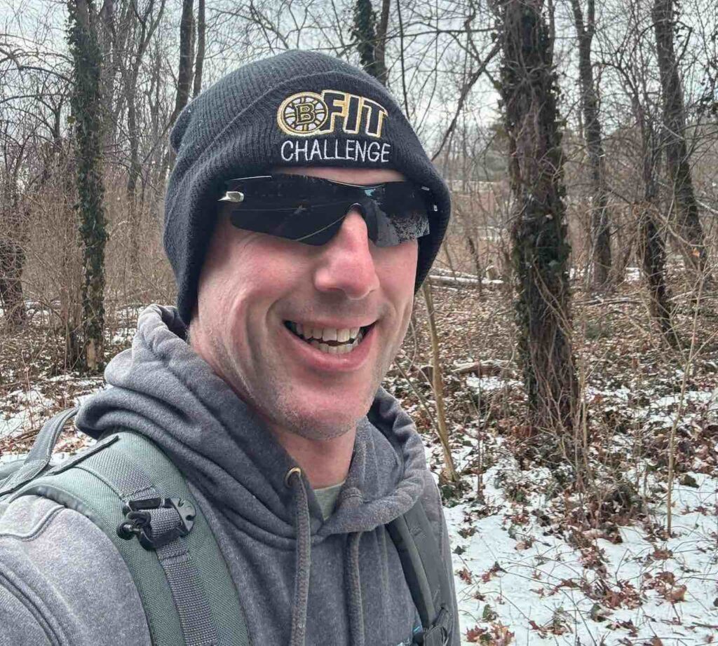 Andrew Staruk running in the woods wearing a BFit beanie.