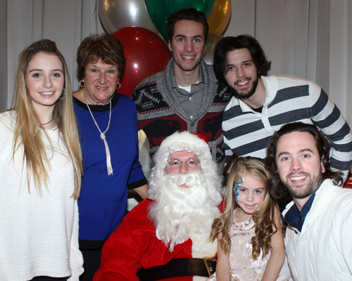 family smiling with santa clause